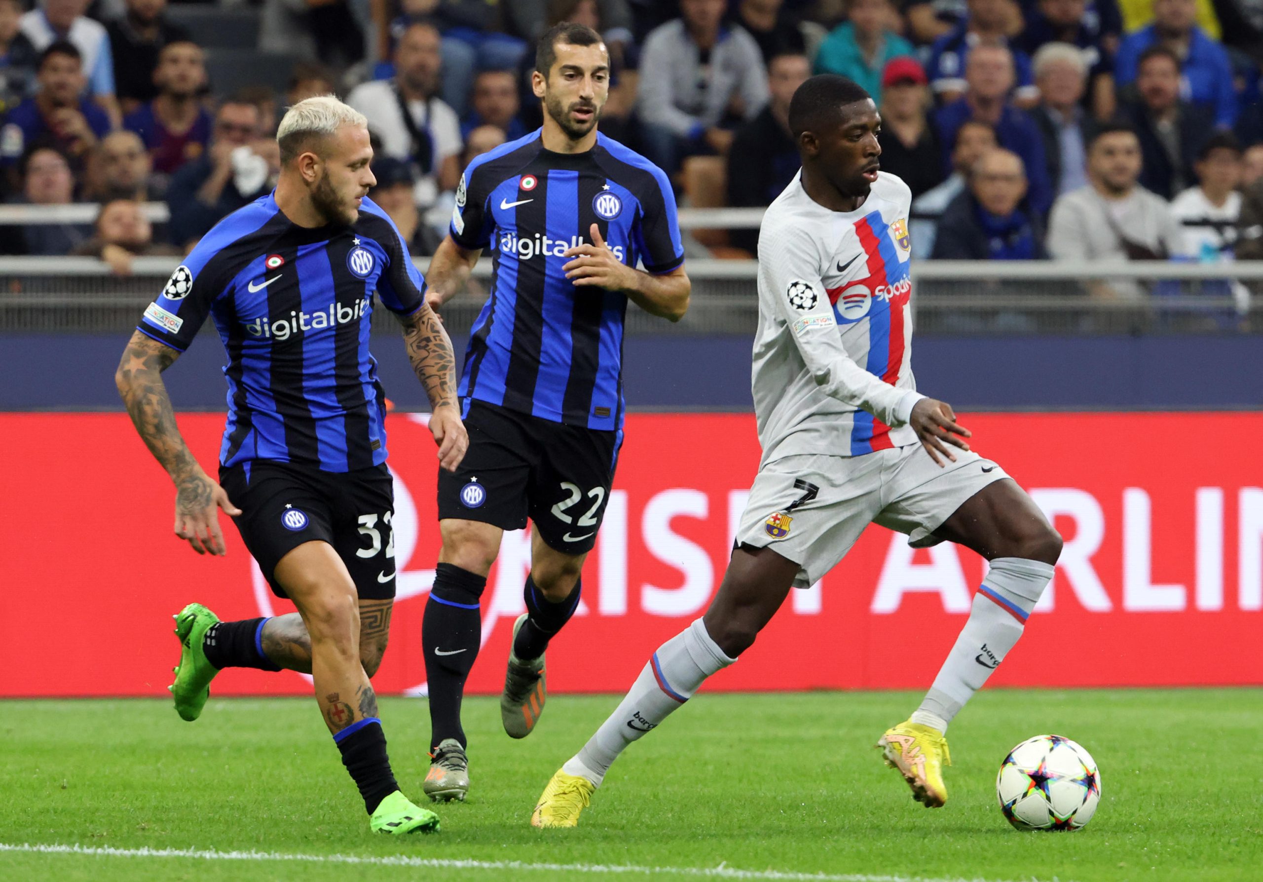 epa10223643 Barcelona's Ousmane Dembele (R) challenges for the ball with Inter Milan?s Federico Dimarco (L) and his teammate Henrih Mkhitaryan during the UEFA Champions League Group C match between FC Inter and FC Barcelona at Giuseppe Meazza stadium in Milan, Italy, 04 October 2022. EPA-EFE/MATTEO BAZZI